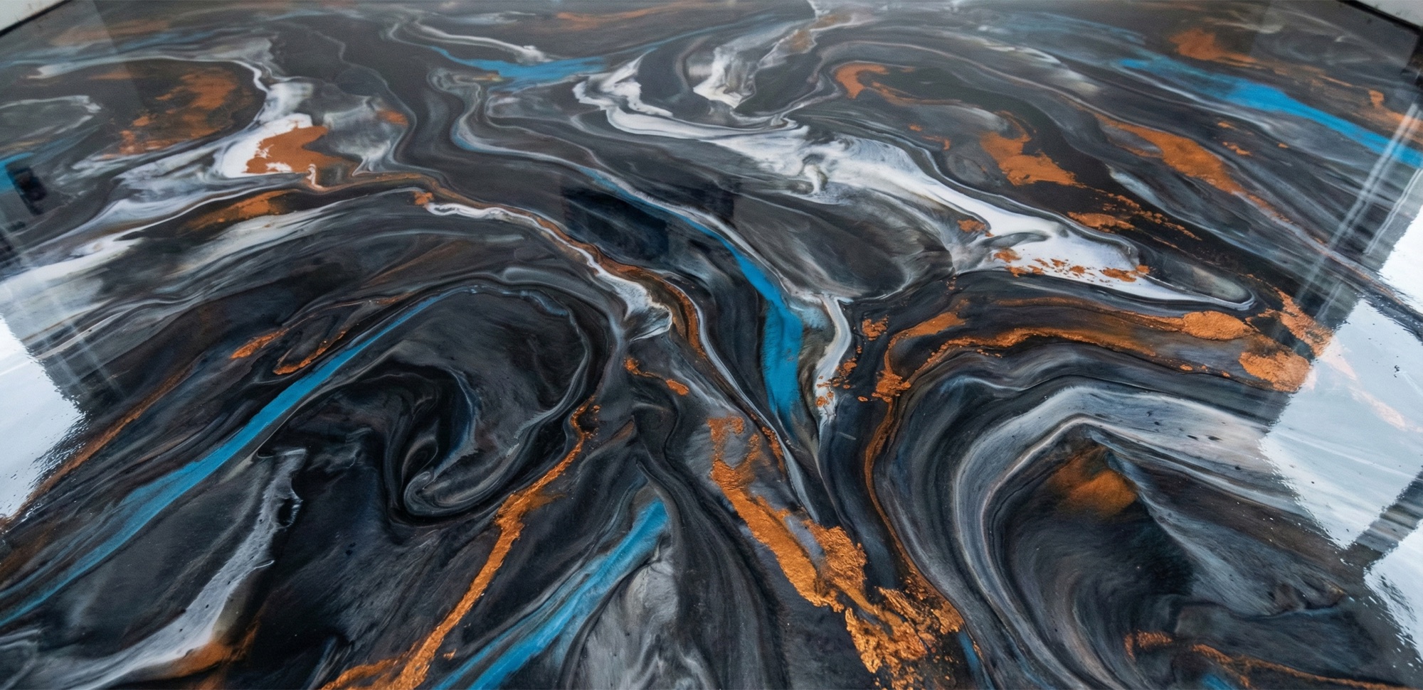 Close detail of a metallic epoxy floor, black and white swirls veined with copper and teal